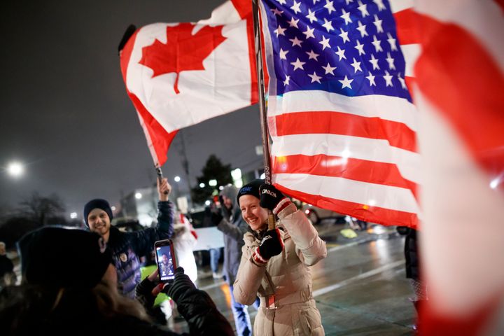 Protesters and supporters wave flags at a blockade at the foot of the Ambassador Bridge, sealing off the flow of commercial traffic over the bridge into Canada from Detroit.